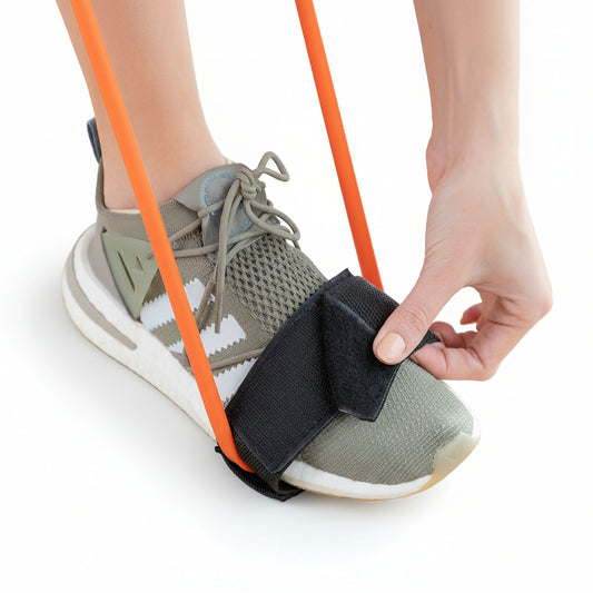 Close-up of foot strapped into glute resistance belt with orange resistance bands, ready for squat exercise