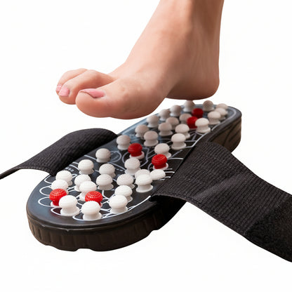 Flexora acupressure massage slipper under a bare foot stimulating white and red pressure nodes
