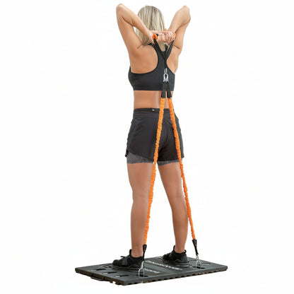 Flexora Portable Training System – woman performing overhead triceps extension with orange resistance bands on base platform on a white background