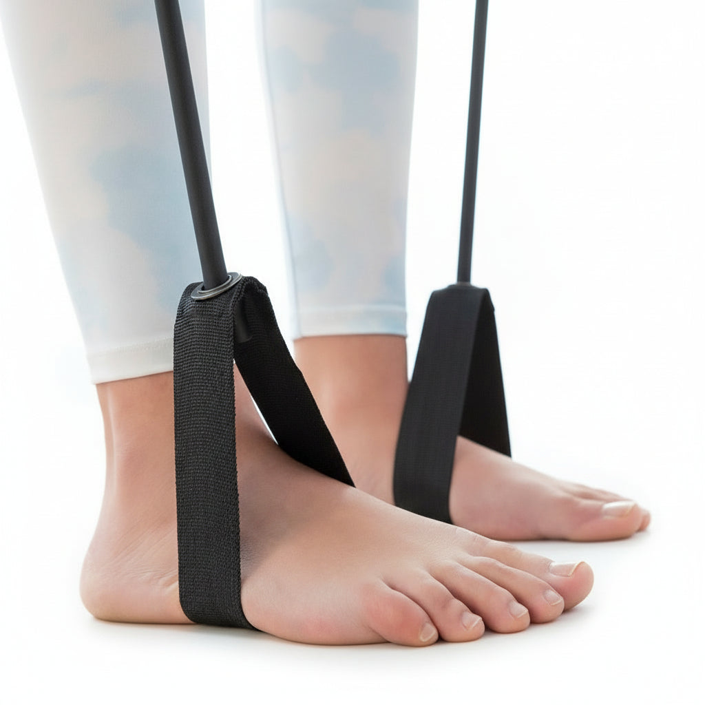 Close-up of feet in black resistance band straps on a white studio background